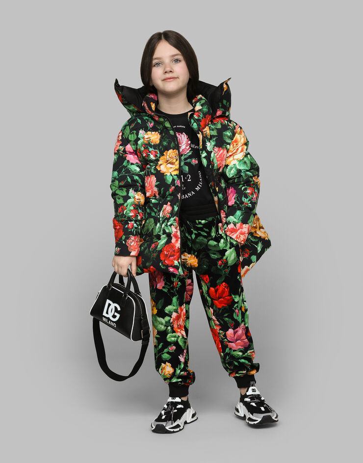 Dolce & Gabbana Long nylon down jacket with rose print over a black background Print L5JBQ5ISMIB