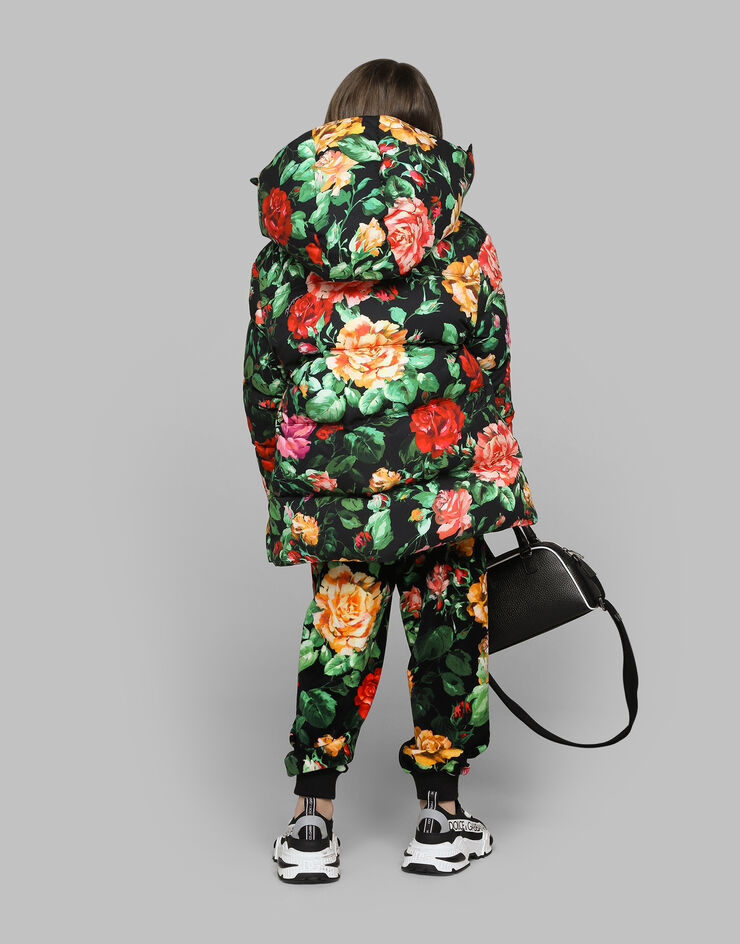 Dolce & Gabbana Long nylon down jacket with rose print over a black background Print L5JBQ5ISMIB